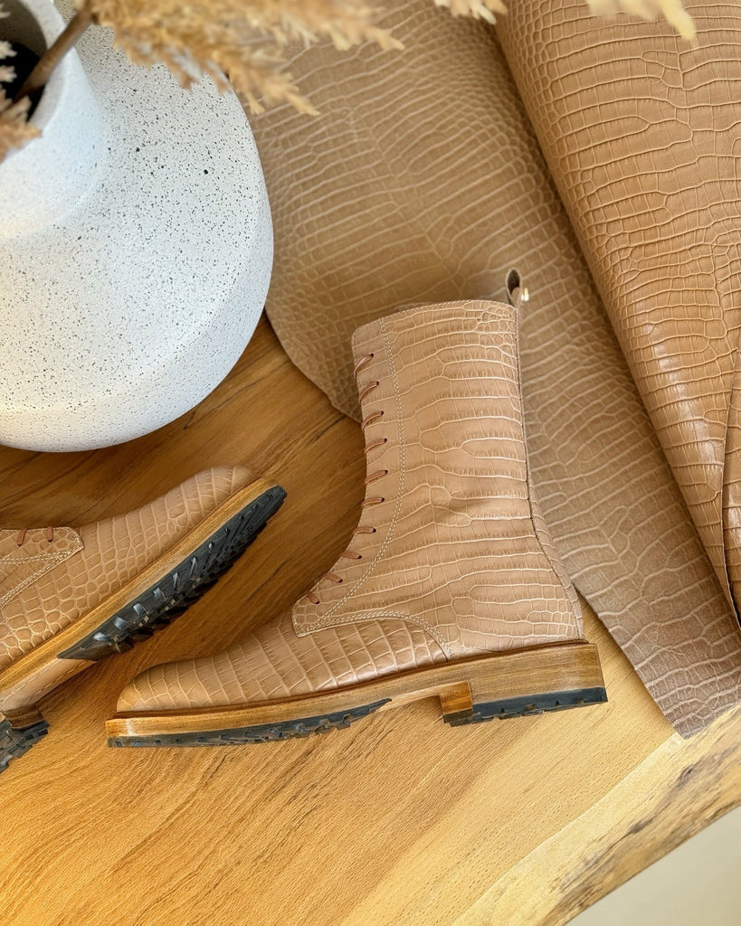 Close-up of a brown leather shoe with a white spherical object and textured surface in the background.